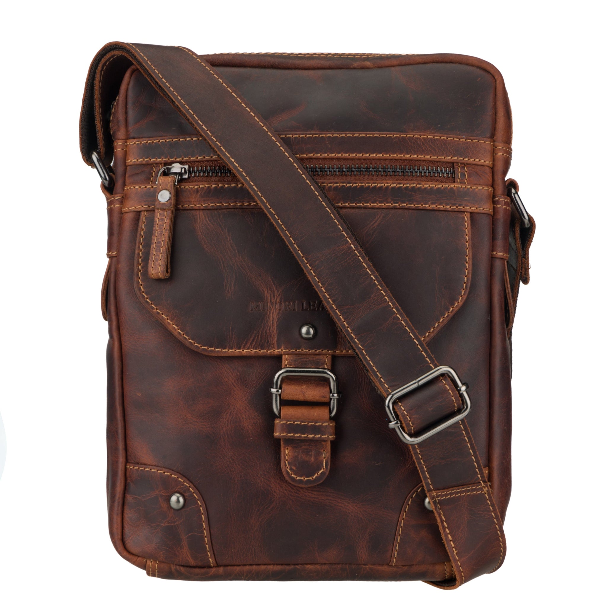 Close-up front view of a brown Minori leather crossbody bag showing zipper pocket, buckle flap, and stitching details.