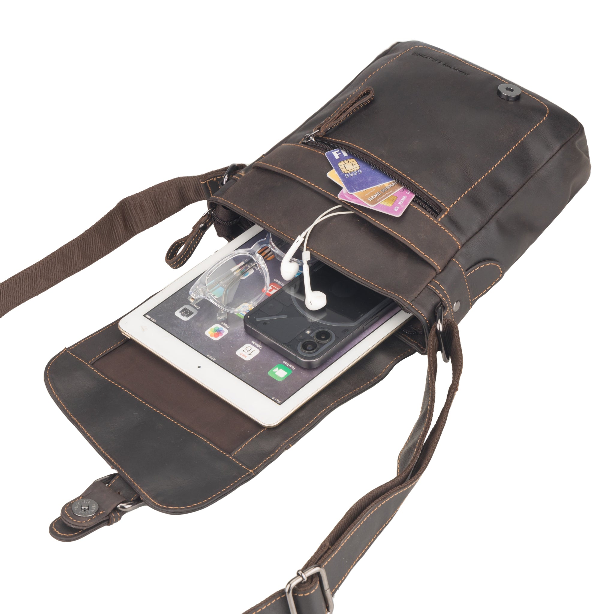 Brown Minori leather crossbody bag with contents like cards, sunglasses, tablet, and earphones spilling out.