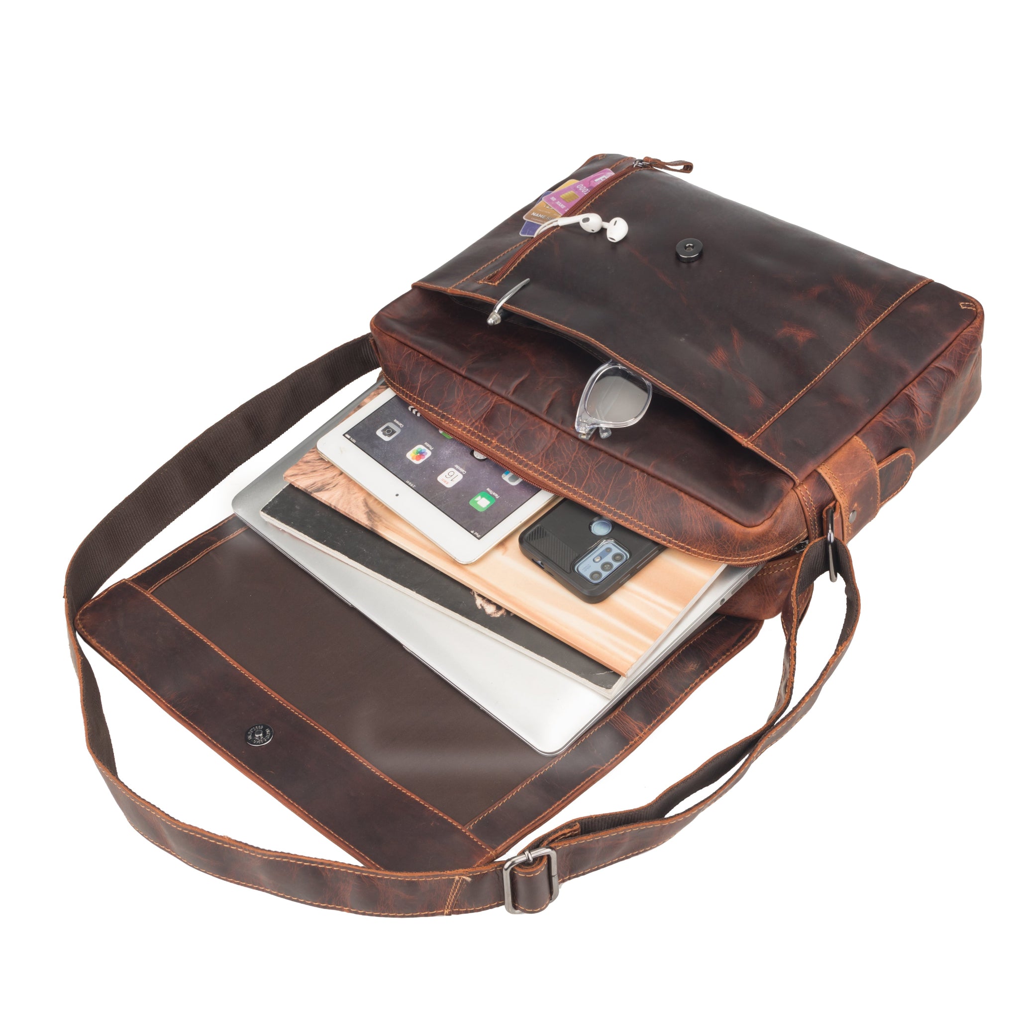 Brown Minori leather bag with a shoulder strap, containing electronic devices on a white background