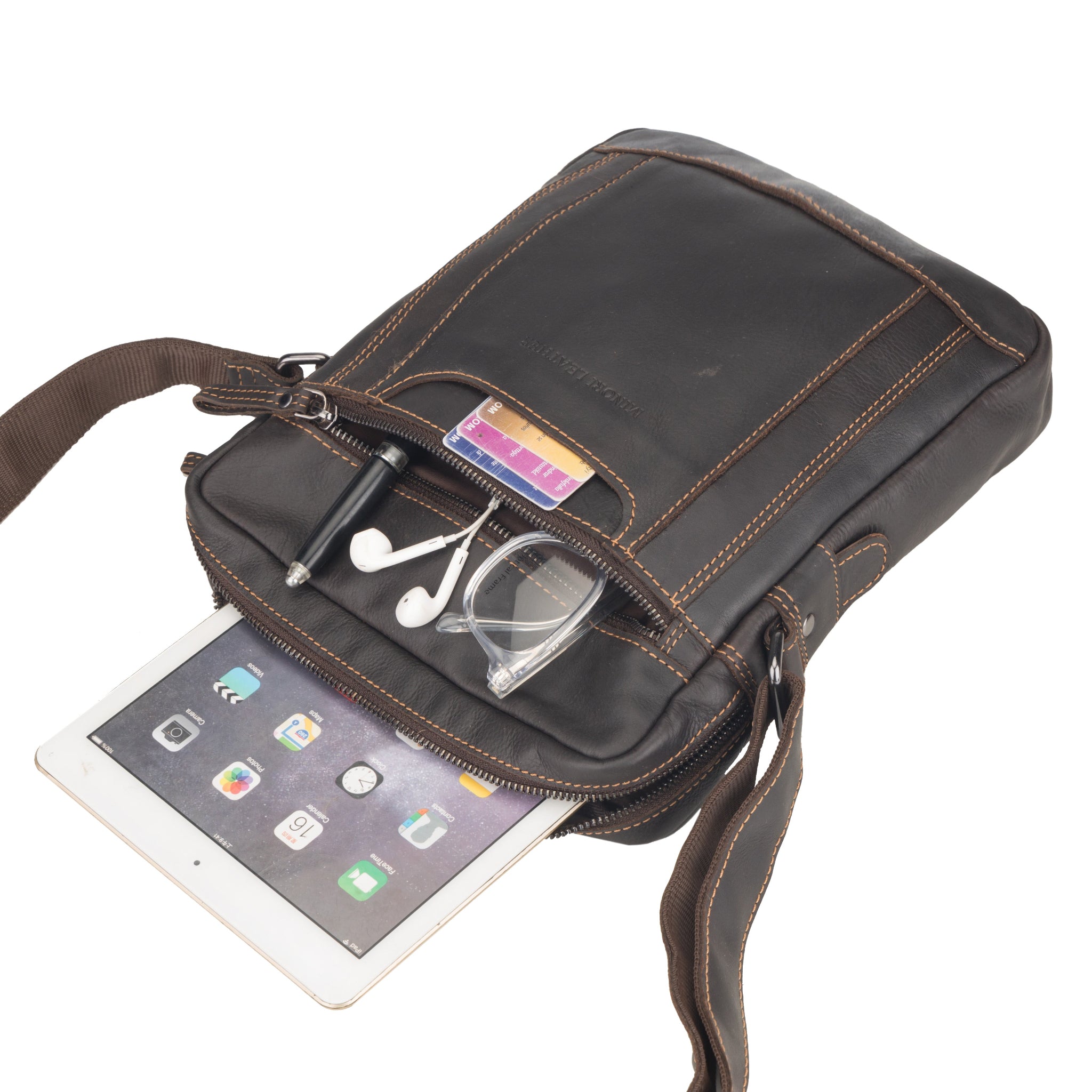 Brown Minori leather crossbody bag with tablet and accessories on a white background