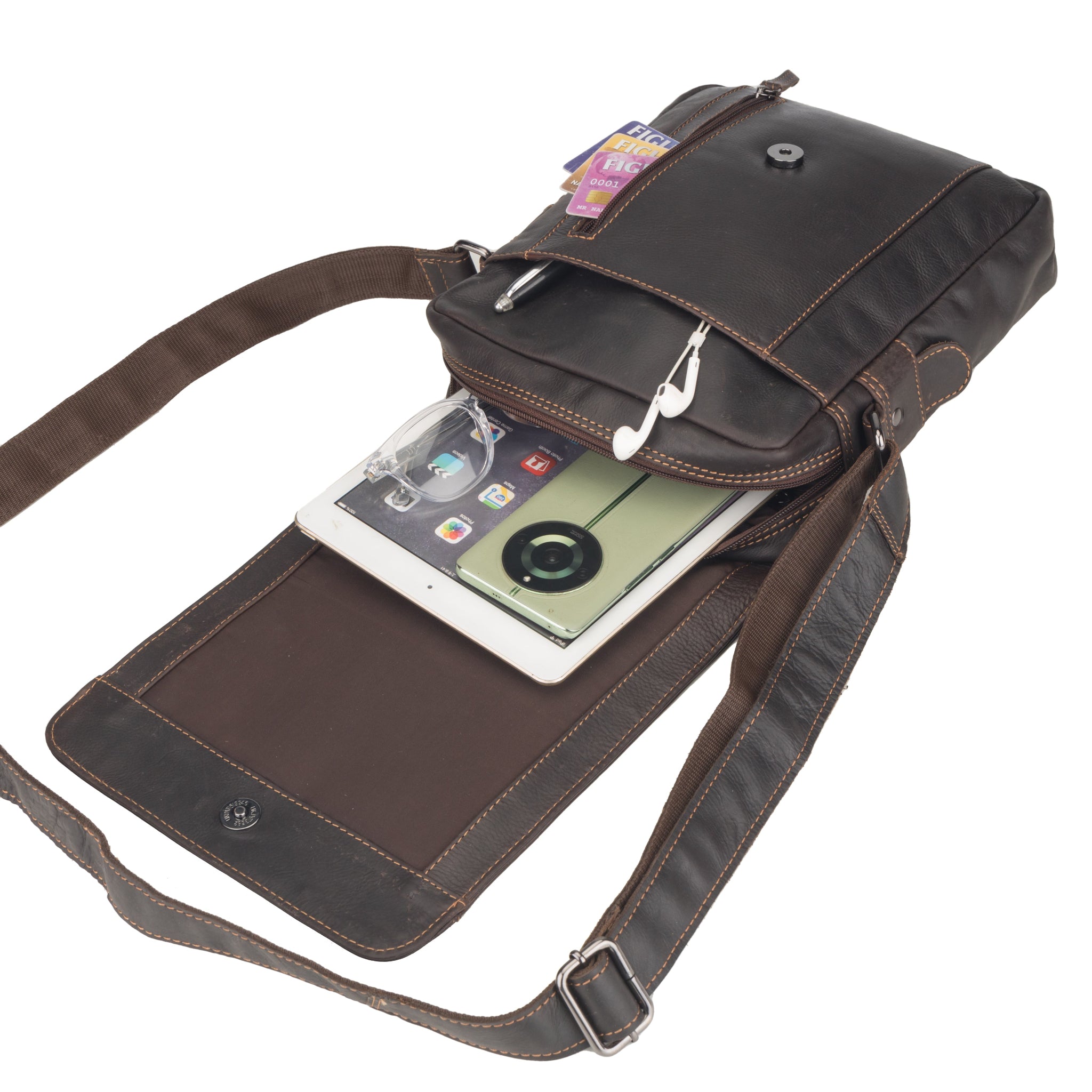 Brown Minori leather crossbody bag with a phone and earbuds on a white background