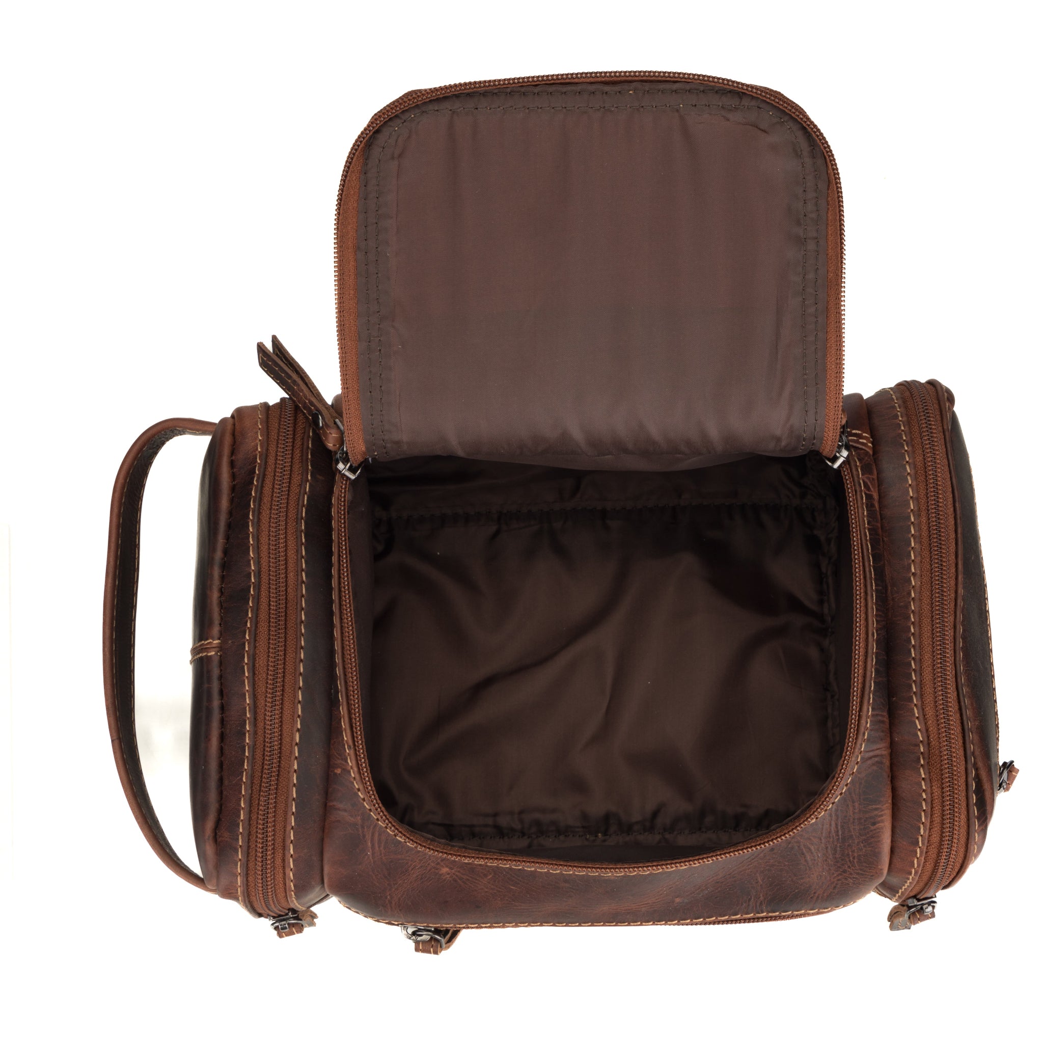 Top view of open chestnut brown Minori leather toiletry bag showing ample interior storage space and neatly stitched interior lining.