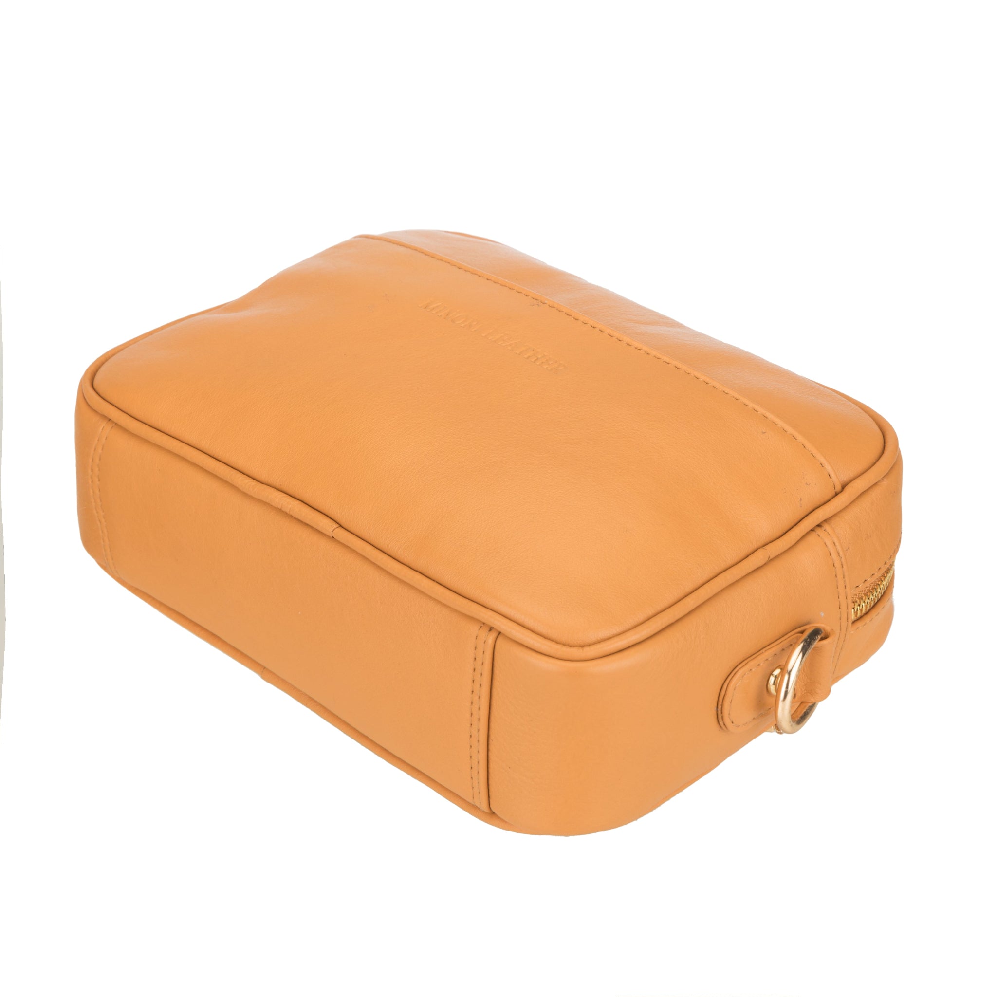 Bottom-side view of a structured tan Minori leather crossbody bag with a gold D-ring attachment.