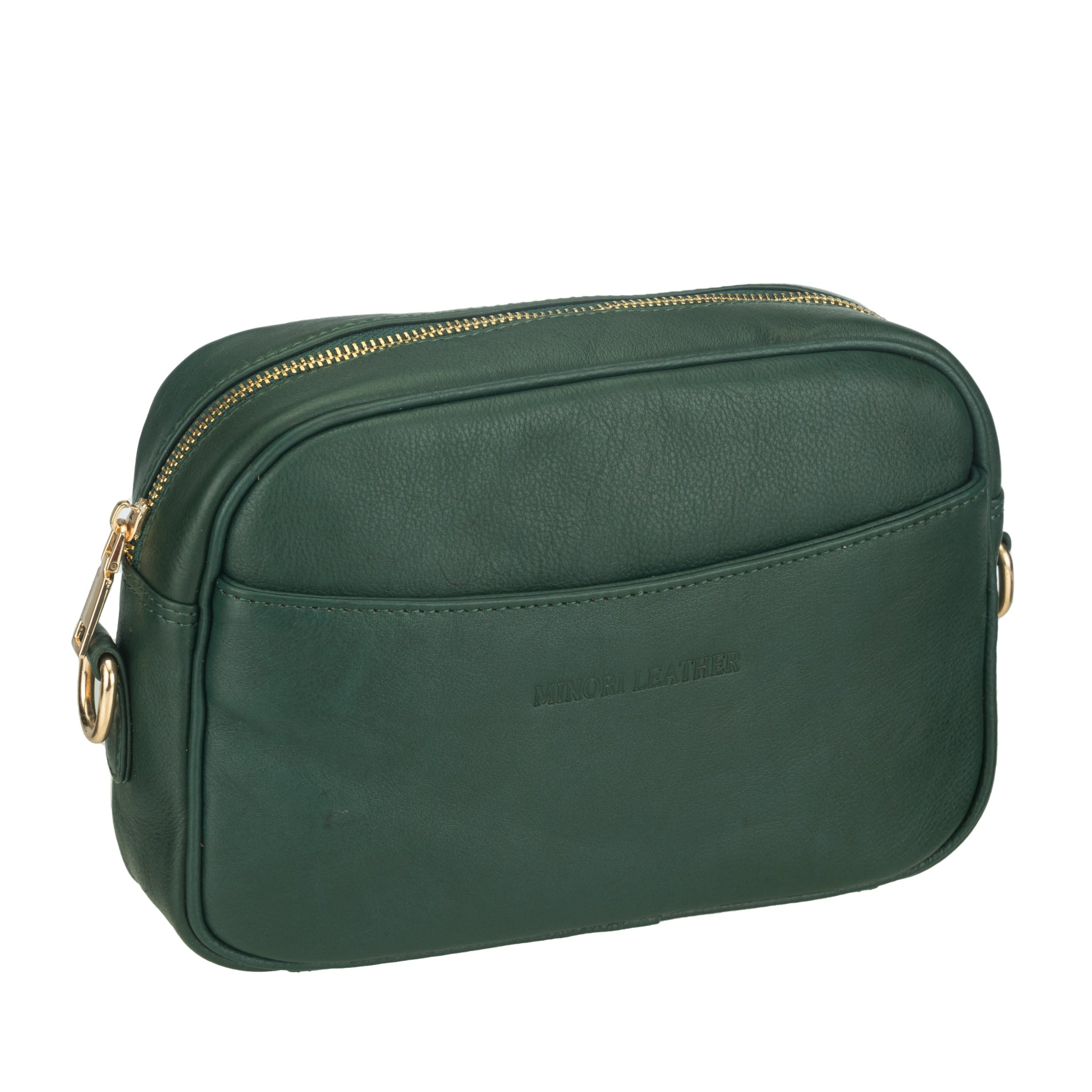 Angled view of a Forest Green Minori leather crossbody bag with a curved front pocket and gold zipper detailing.
