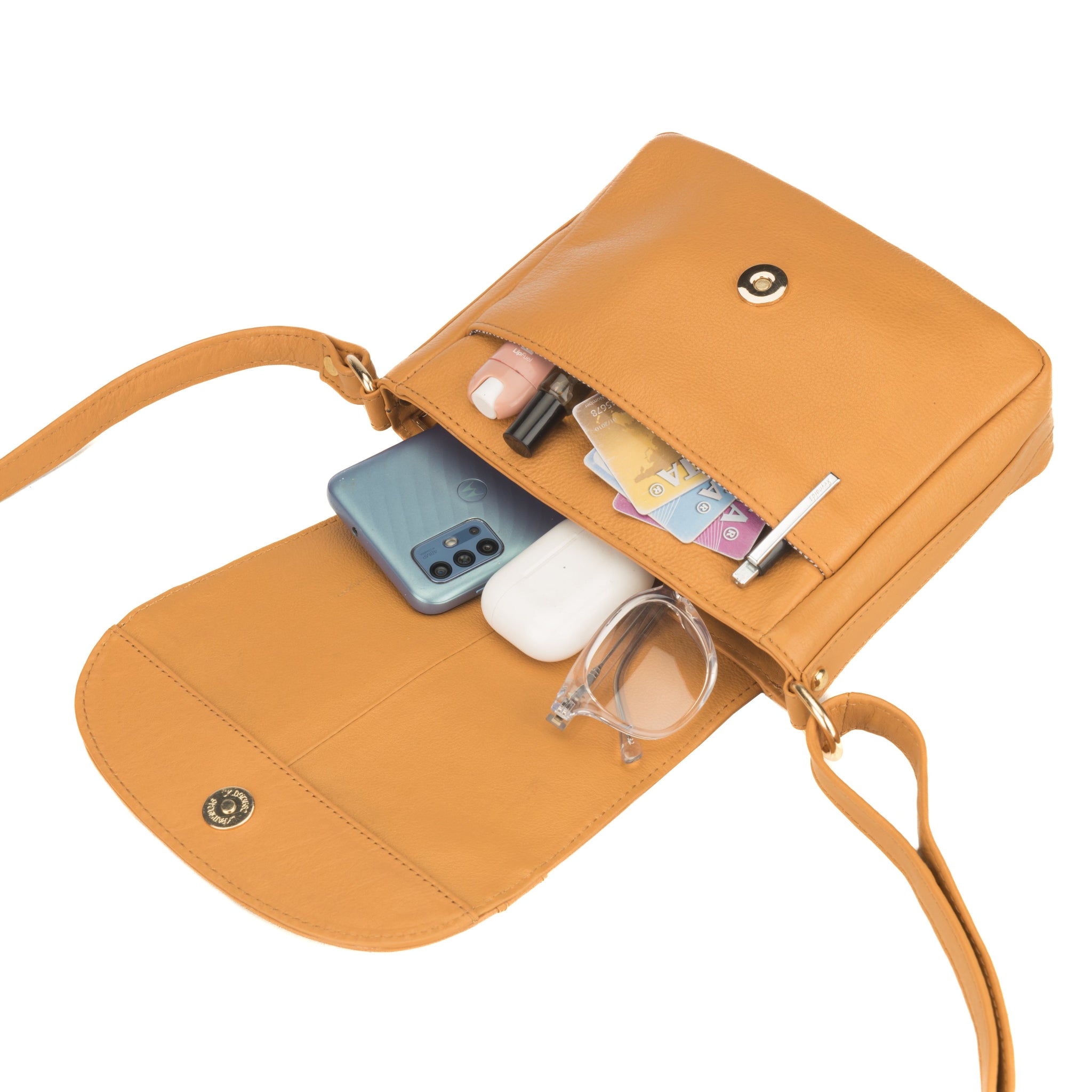 Tan Minori leather crossbody bag with items like a phone, cards, and glasses inside on a white background