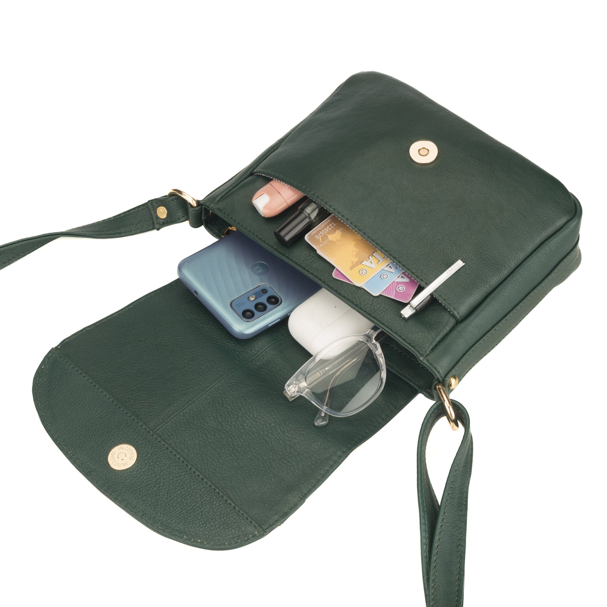 Forest Green Minori leather crossbody bag with compartments containing a phone, cards, and sunglasses on a white background