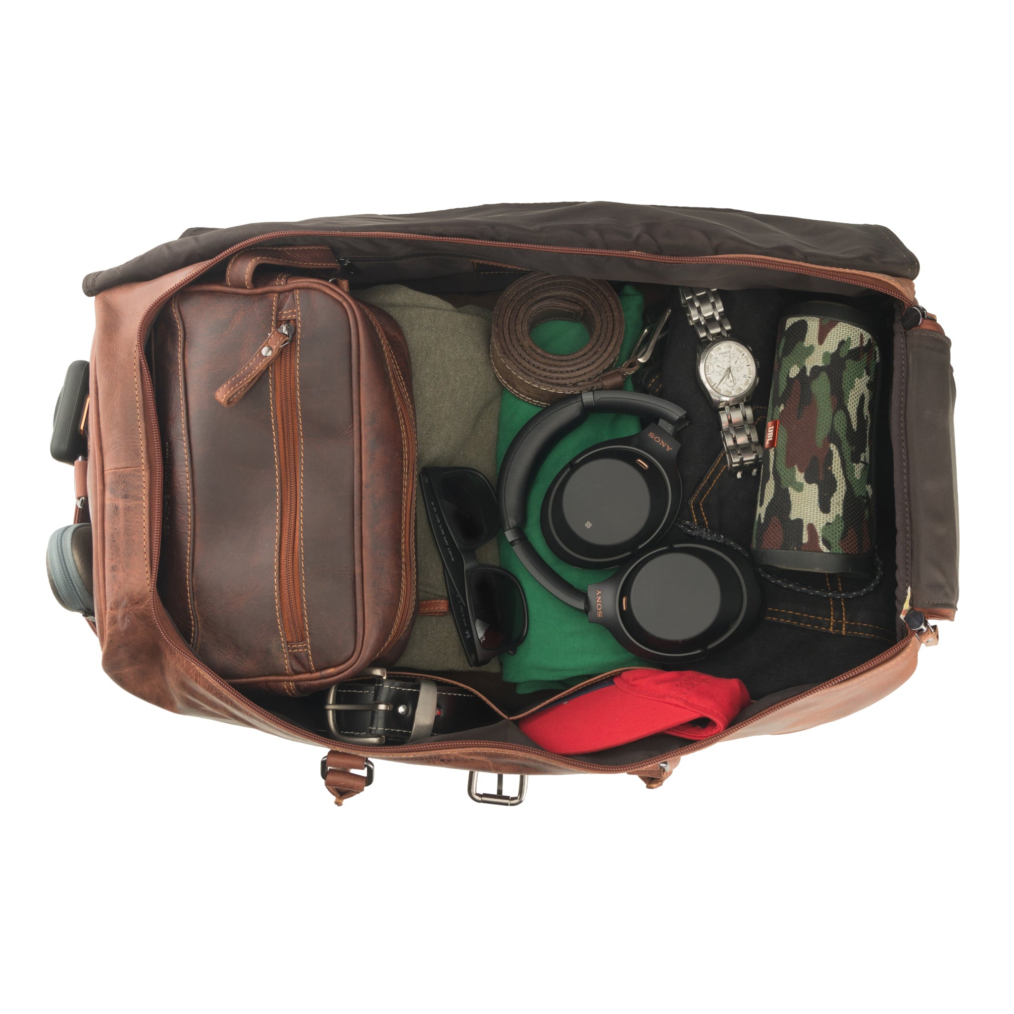 Overhead view of an open chestnut brown Minori leather duffle bag filled with travel essentials including clothes, headphones, sunglasses, and a toiletry kit, illustrating its large storage capacity.