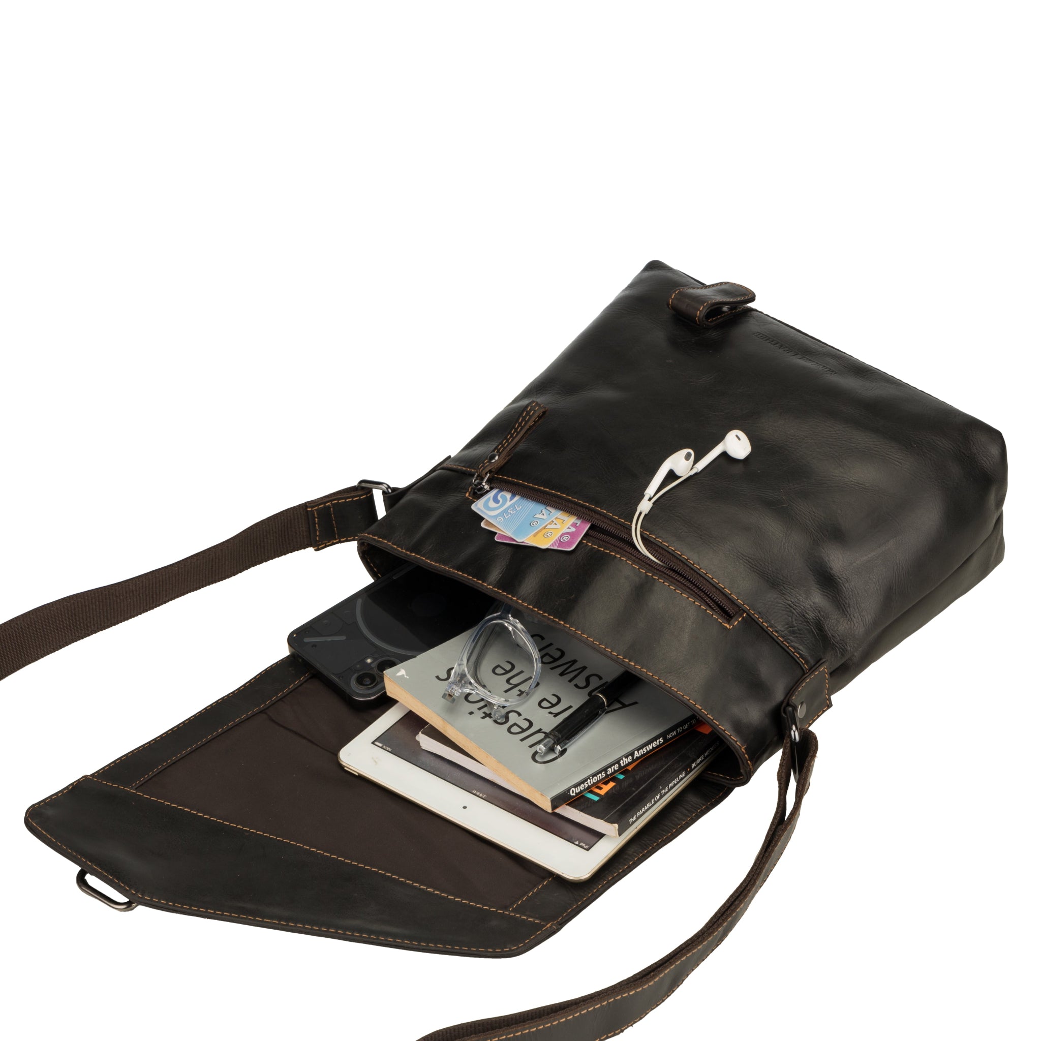 Open view of a Brown Minori leather crossbody bag filled with items like a book, tablet, glasses, cards, and earphones to show storage capacity.