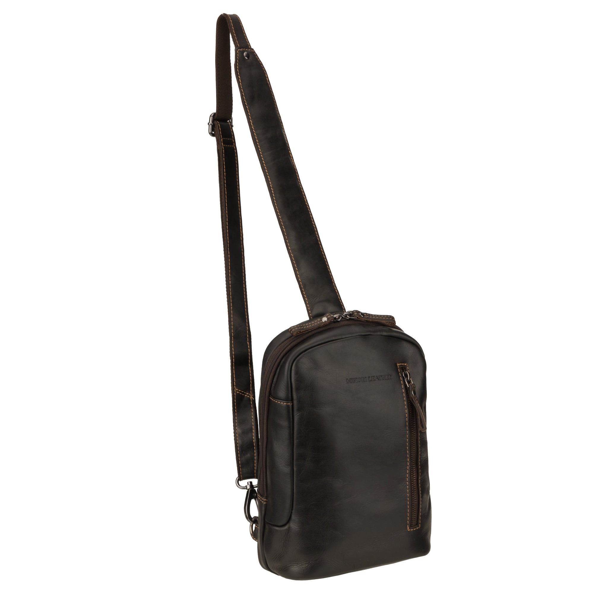 Angled front view of a brown Minori leather crossbody sling bag highlighting the main compartment and zippered front pocket.