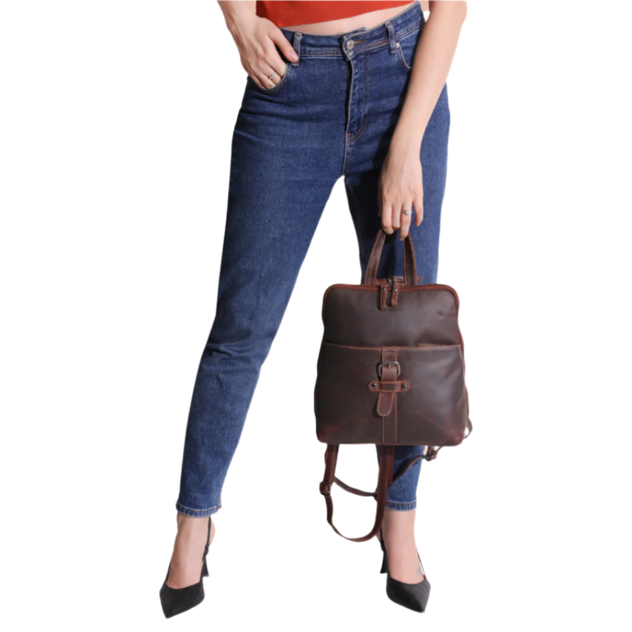 Close-up of model's lower half holding the chestnut brown Minori leather backpack by the top handle.