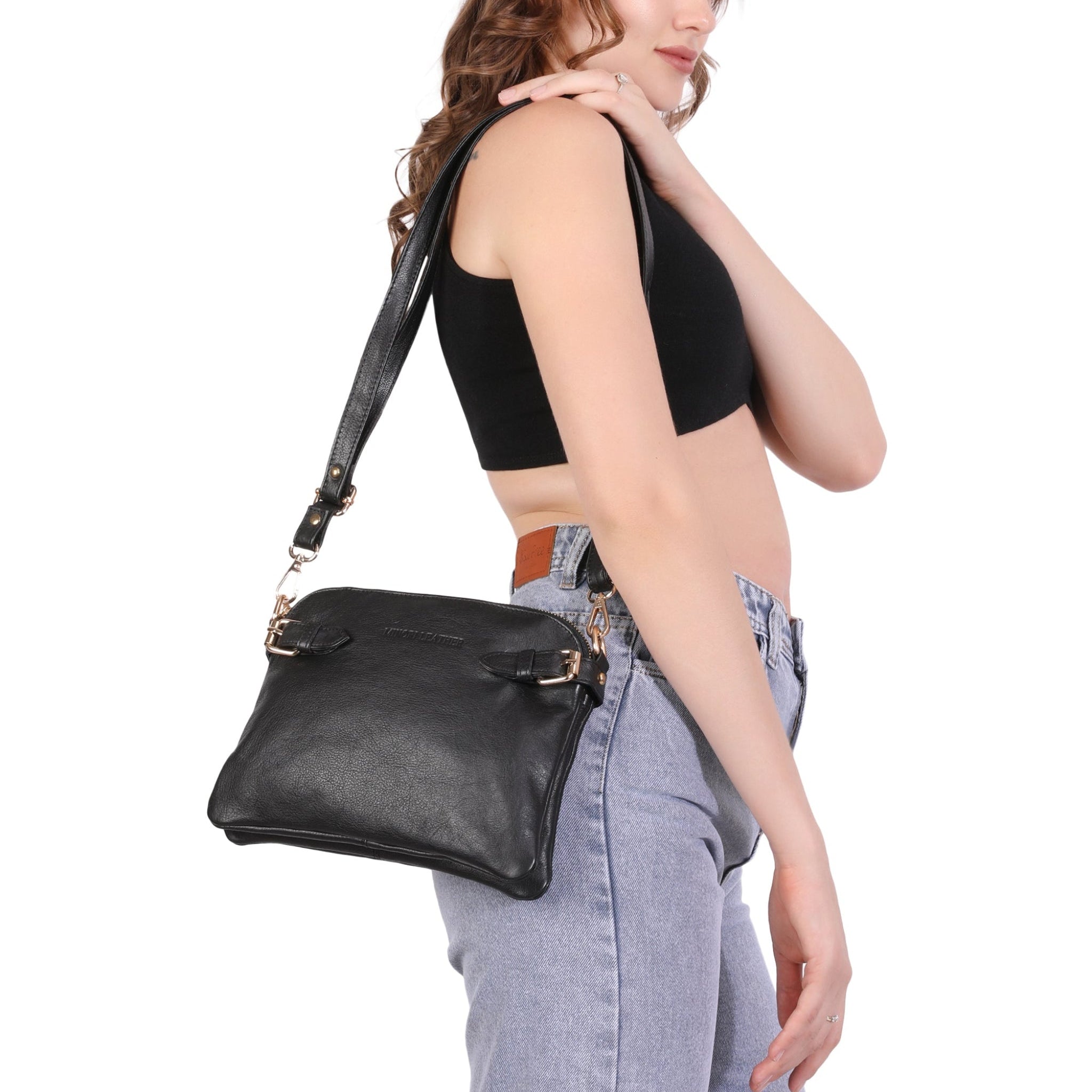 Woman carrying a black Minori leather handbag on a white background