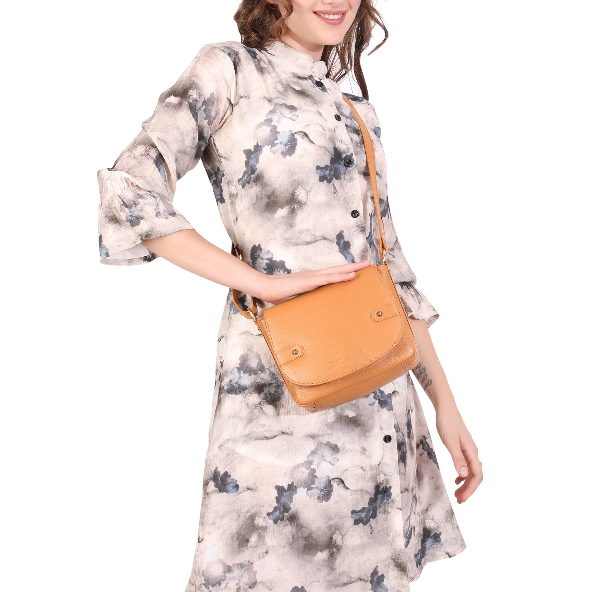 Woman wearing a floral dress with a Tan Minori leather bag on a white background