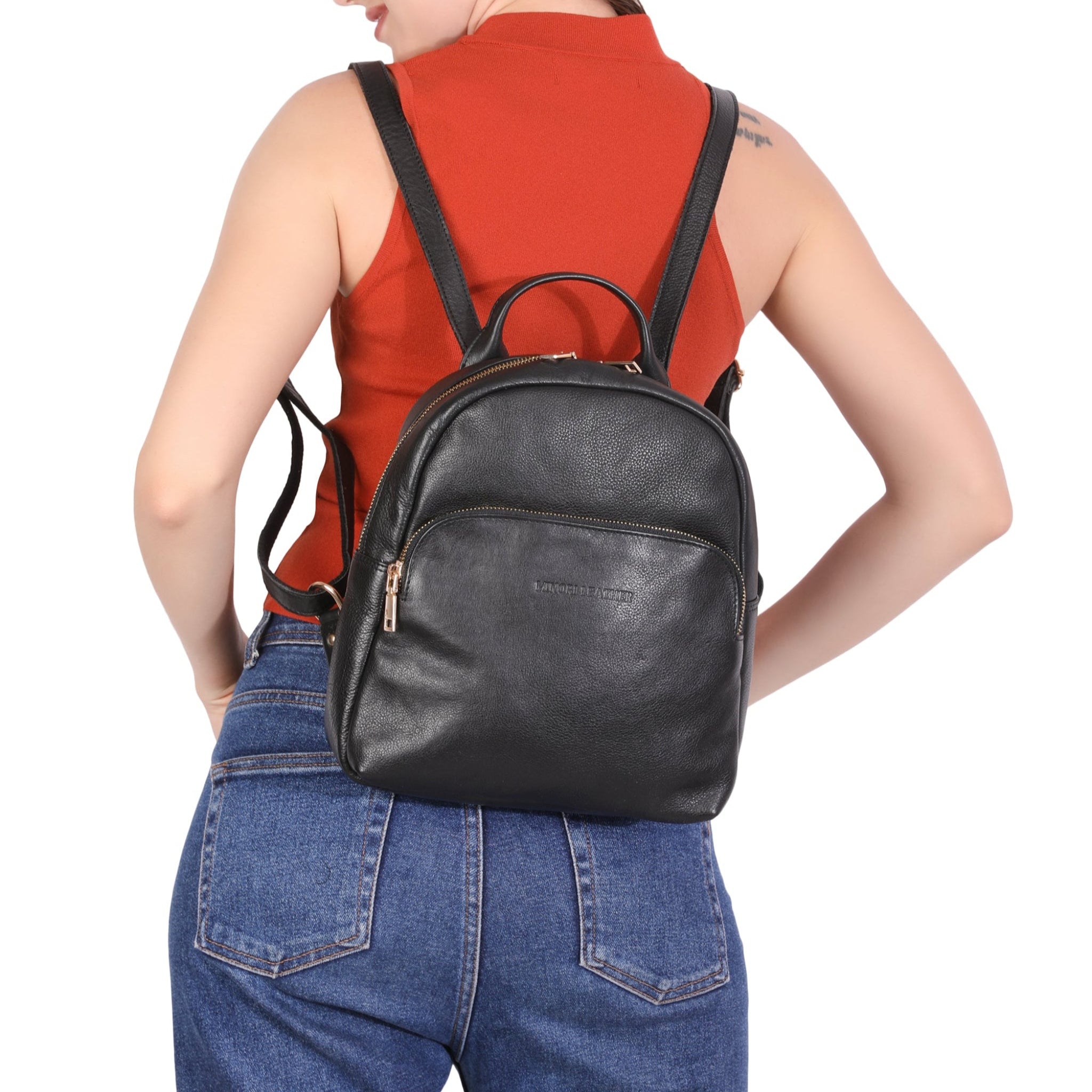 Woman wearing a black Minori leather backpack on a white background