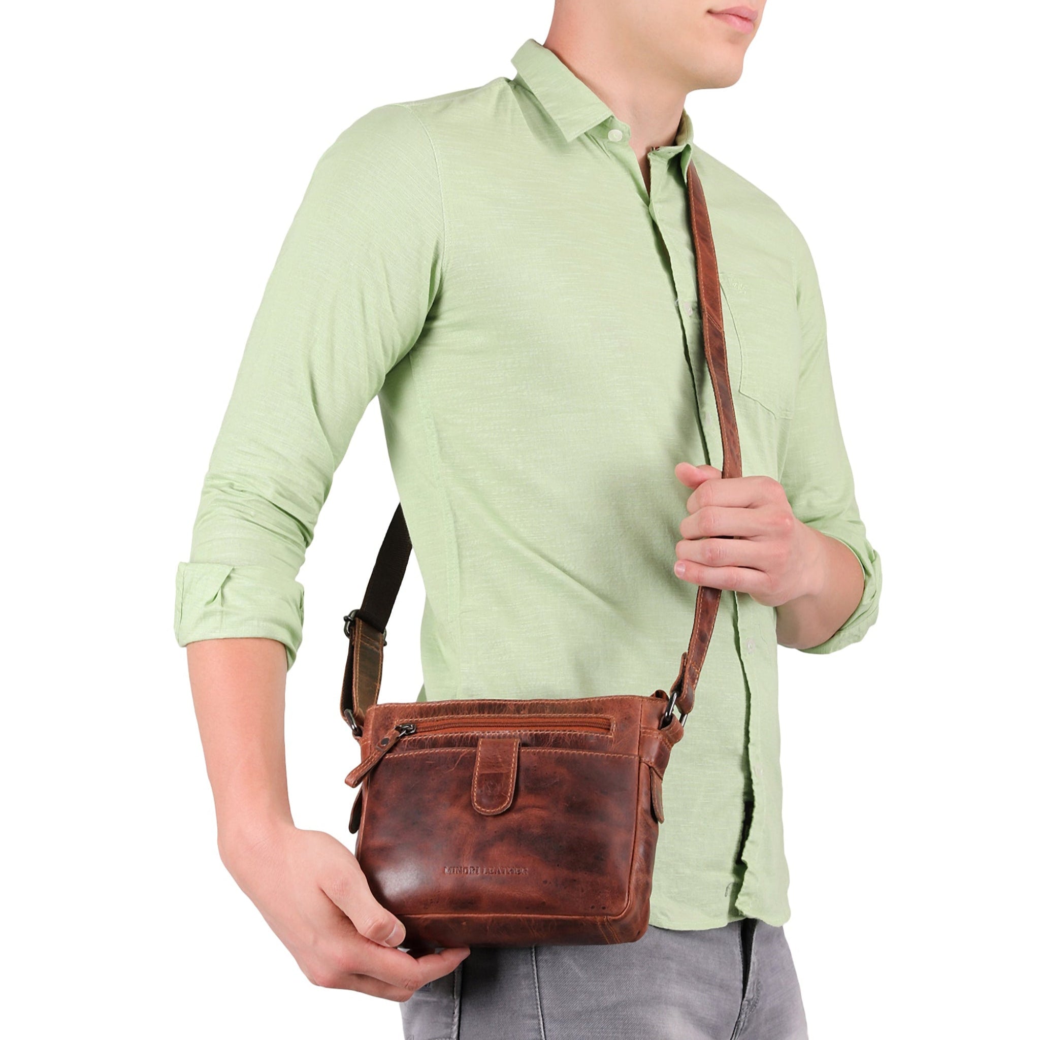 Man holding a brown Minori leather bag against a white background