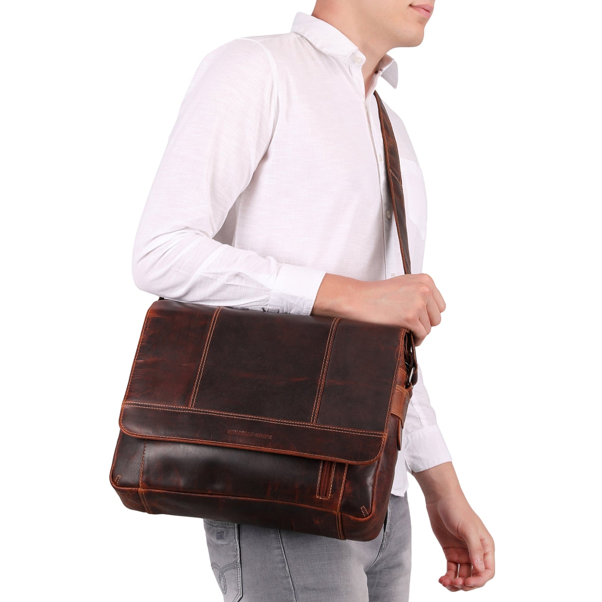 Man holding a brown Minori leather messenger bag against a white background