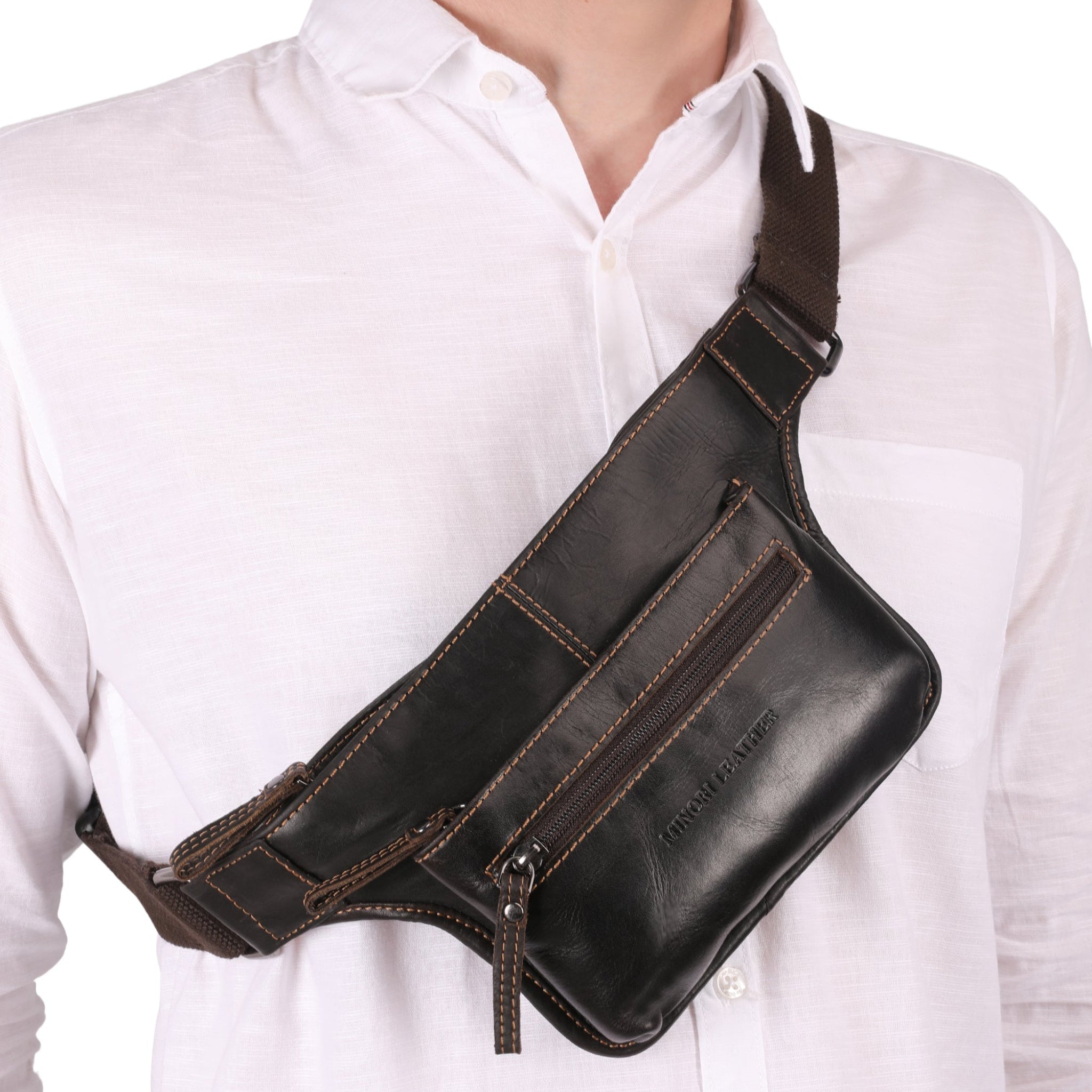 close-up view of brown Minori leather waist bag featuring multiple compartments and an adjustable strap with buckle closure.