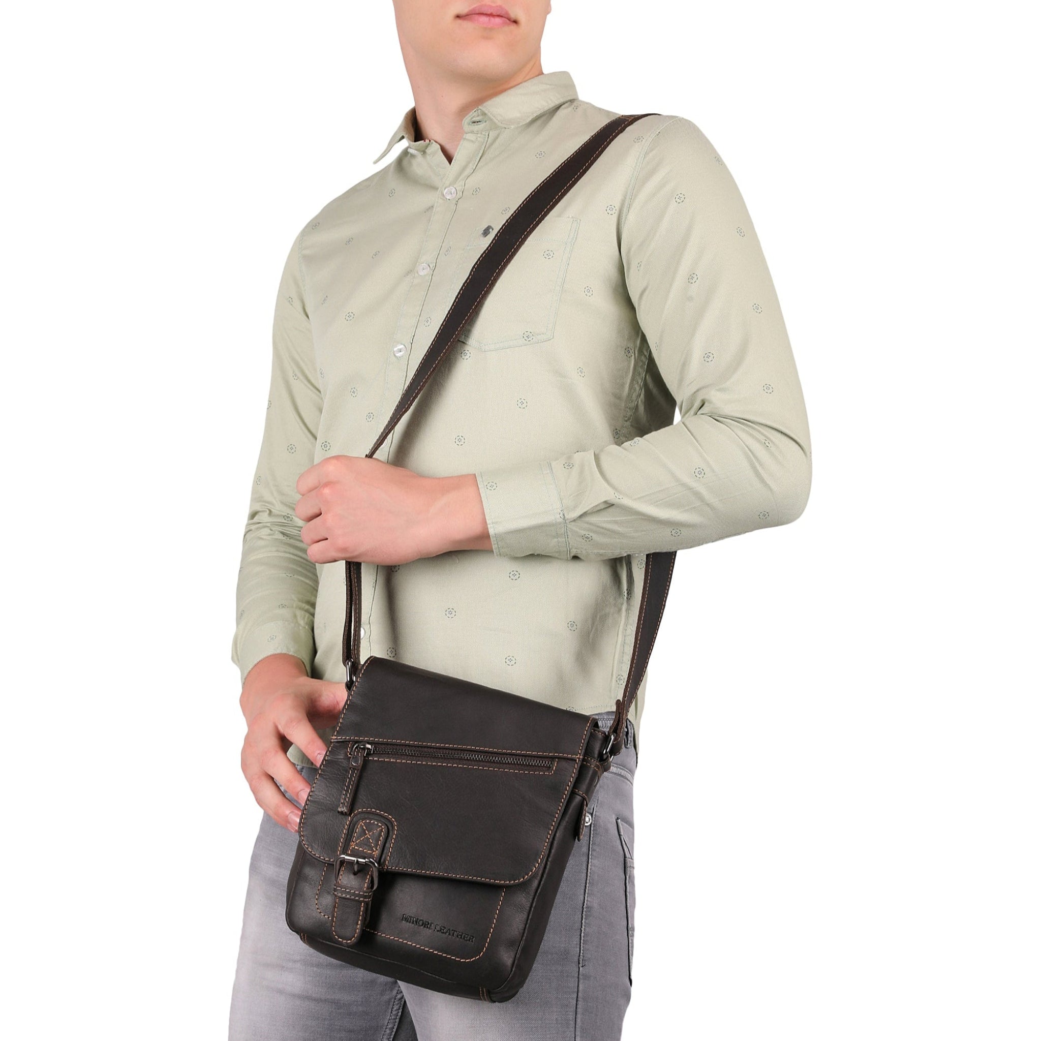 Man posing with a brown Minori leather crossbody bag slung over his shoulder - side view.