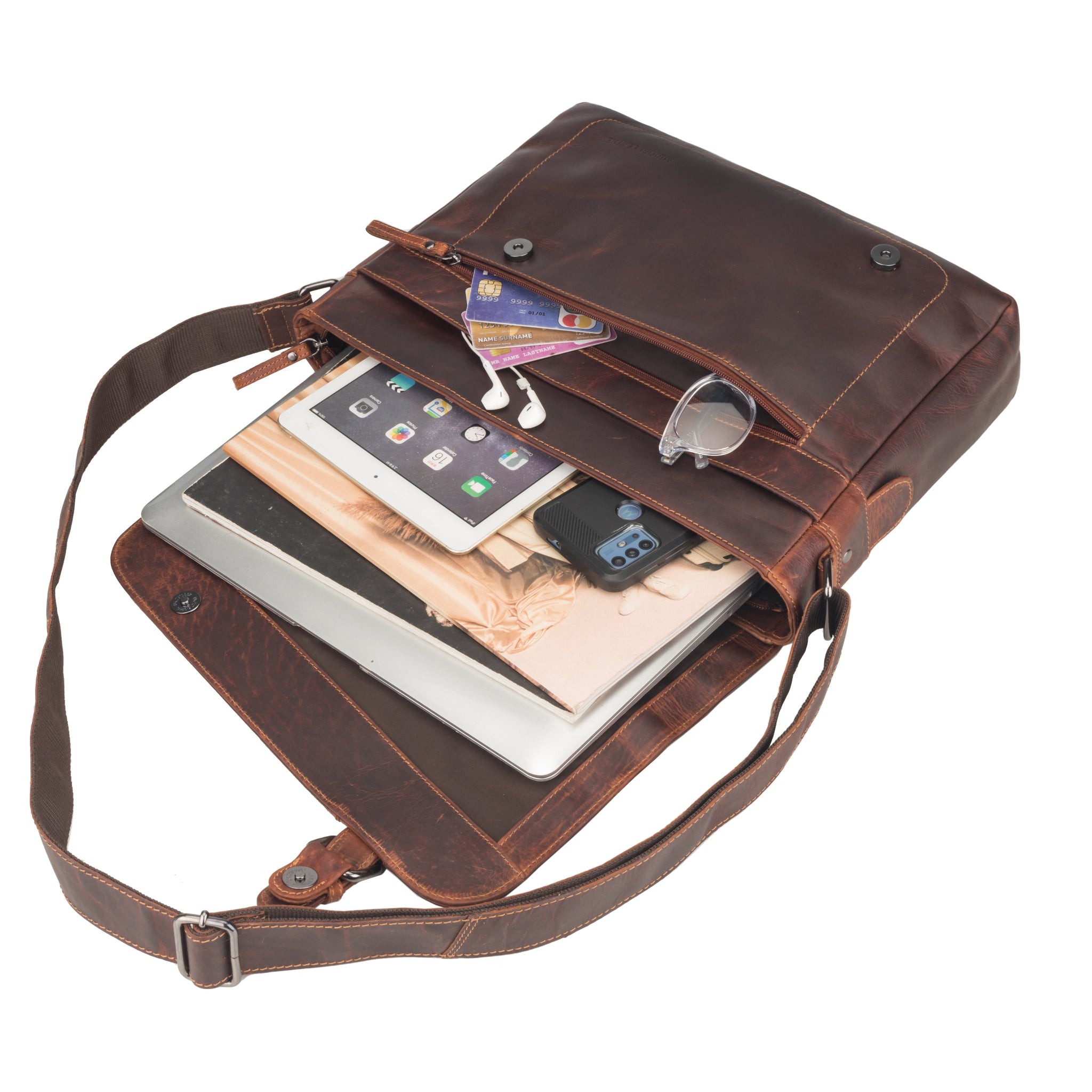 Brown Minori leather crossbody bag with electronic devices and items inside on a white background