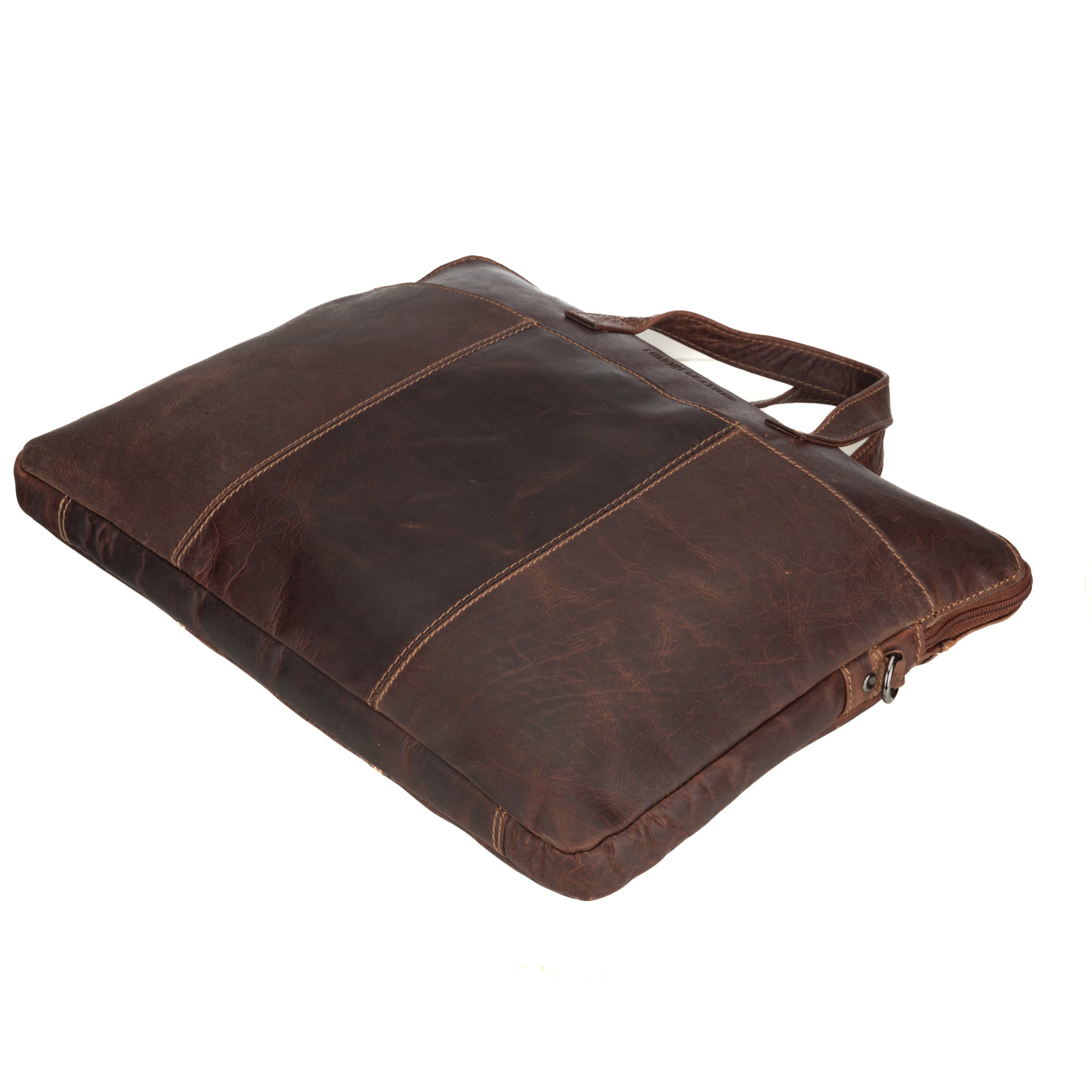 Side-angled shot of a slim Minori leather laptop bag lying flat, highlighting its compact and structured design.