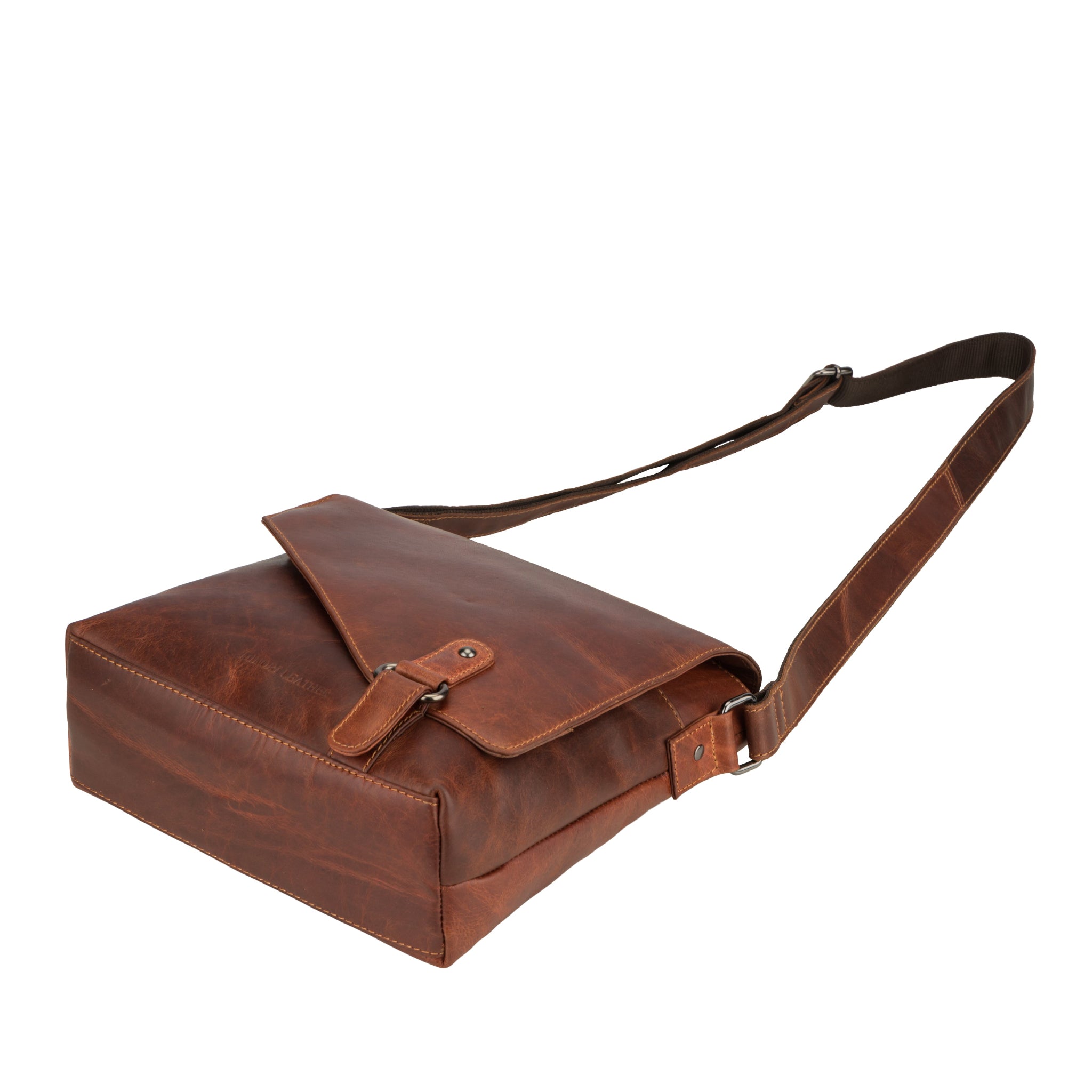  A low-angle perspective of the Minori leather crossbody bag lying flat, displaying its bottom structure and adjustable strap.