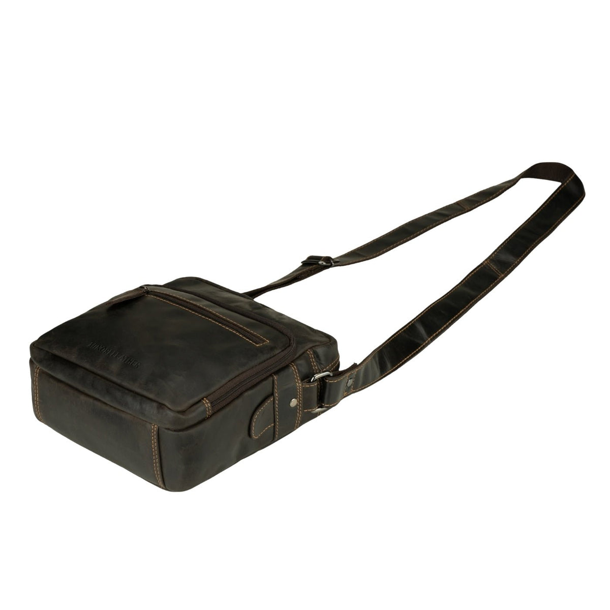 Minori Leather Harbor brown leather crossbody messenger bag hanging on a hook, showcasing its compact design and adjustable strap.