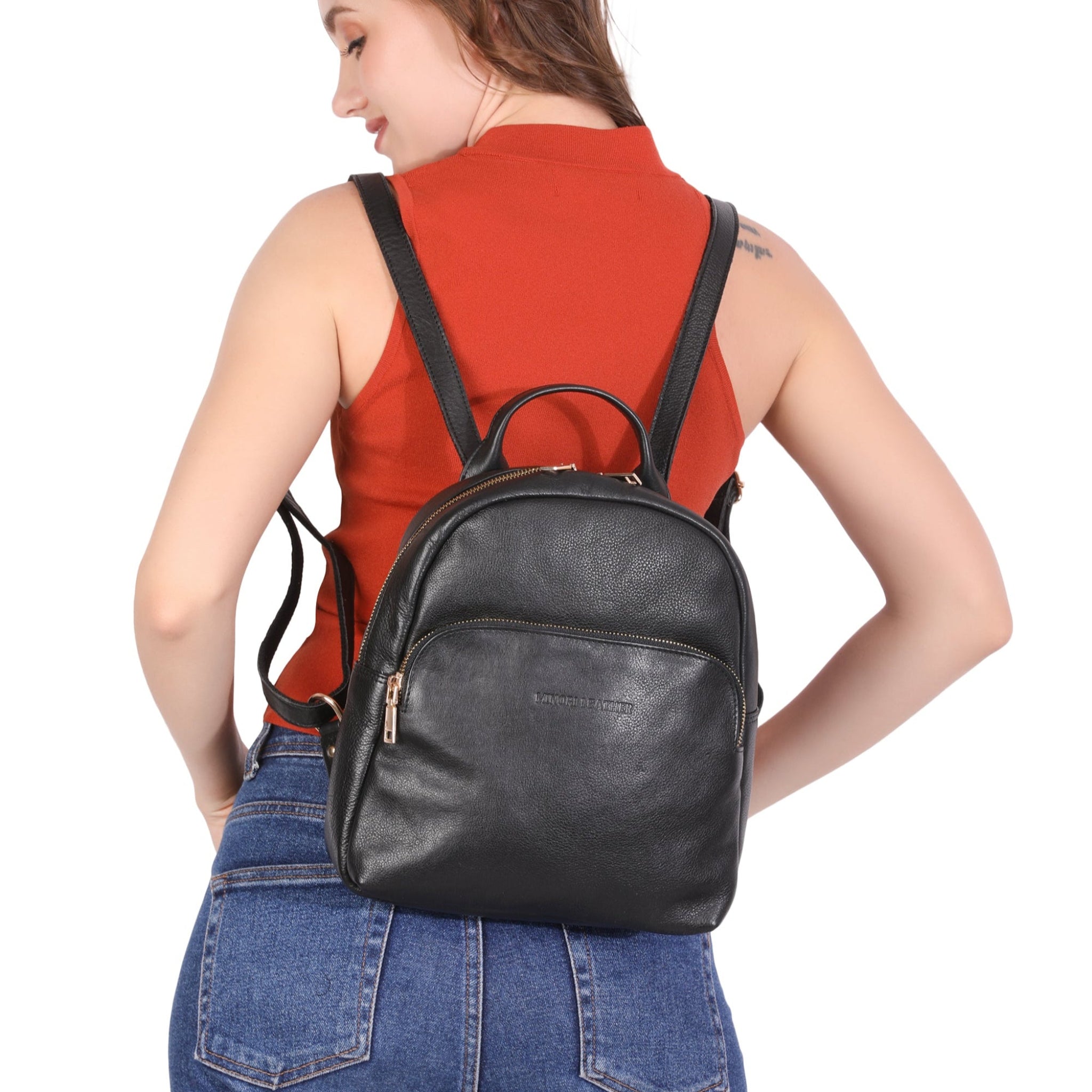 Woman wearing a black Minori leather backpack on a white background